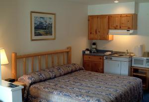 a bedroom with a bed and a small kitchen at Edgewater Inn Shady Cove in Shady Cove