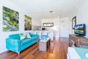 a living room filled with furniture and a tv at Cascade Gardens in Cairns