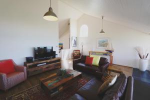ein Wohnzimmer mit einem Sofa und einem TV in der Unterkunft Caledonian Inn in Robe