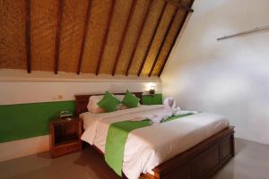 a bedroom with a bed with a stuffed animal on it at Jingga Bungalow Penida in Nusa Penida