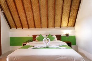 Un dormitorio con una cama con toallas blancas. en Jingga Home Penida, en Nusa Penida 22 fotos más