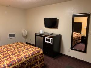 Habitación de hotel con cama y TV de pantalla plana. en Seaview Inn Grover Beach en Grover Beach