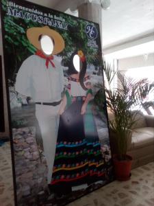 um cartaz de uma mulher vestindo um vestido e um chapéu em Hotel Claudia em Macuspana