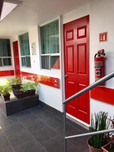 una puerta roja en el lateral de un edificio en Metropolis Suites Ejecutivas en Puebla