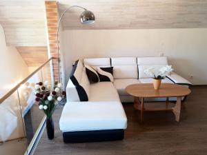 a living room with a white couch and a table at Apartamentai Karklėje in Karklė