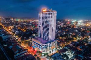 un edificio alto con un cartel encima de él por la noche en Muong Thanh Luxury Bac Ninh Hotel, en Bắc Ninh