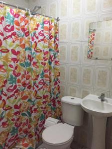 a bathroom with a toilet and a sink and a shower curtain at Hotel Isla Bella Talca in Talca +43 photos