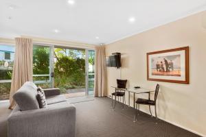 a living room with a couch and a table at Aristotles North Shore in Auckland