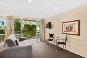 sala de estar con sofá y mesa en Aristotles North Shore en Auckland