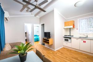 a living room with a couch and a kitchen at Clarence Head Caravan Park in Iluka