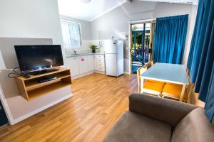 
a living room filled with furniture and a tv at Clarence Head Caravan Park in Iluka
