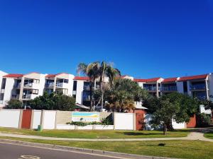 Un edificio con palmeras frente a una calle. en Casablanca Beachfront Apartments, en Caloundra