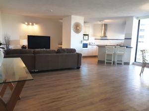 Una sala de estar con un sofá y una cocina. en Casablanca Beachfront Apartments, en Caloundra