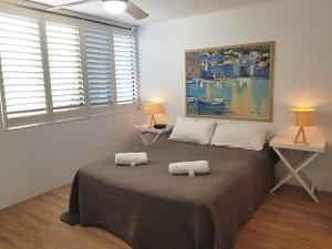 
a bedroom with a bed, a desk and a painting on the wall at Casablanca Beachfront Apartments in Caloundra
