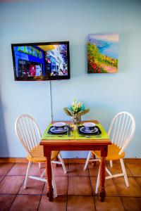 a dining room table with two chairs and a tv at Leucadia Beach Inn in Encinitas