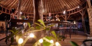 eine Gruppe von Personen, die in einem Restaurant an Tischen sitzen in der Unterkunft Pearl Beach Resort Gili Asahan in Gili Asahan