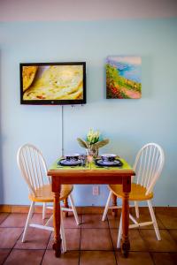 a dining room table with two chairs and a painting at Leucadia Beach Inn in Encinitas