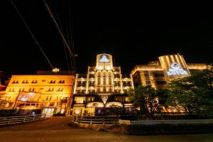 a large building with a clock tower at night at Hotel Lotus Otsu (Adult Only) in Otsu