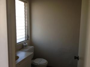 uma casa de banho com um WC e uma janela em Golden Hills Motel em Tehachapi