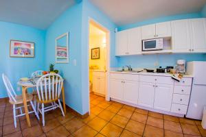 a kitchen with blue walls and a table and chairs at Leucadia Beach Inn in Encinitas