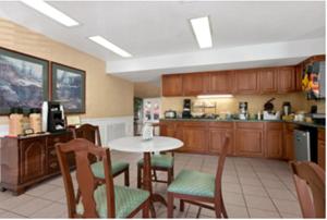 a kitchen with a table and chairs and a table and a counter at Baymont by Wyndham Roanoke Rapids in Roanoke Rapids