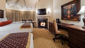 a hotel room with a fireplace and a television at Victorian Inn in Monterey