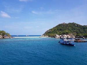 a boat in the water near a small island at Nangyuan Island Dive Resort in Ko Tao