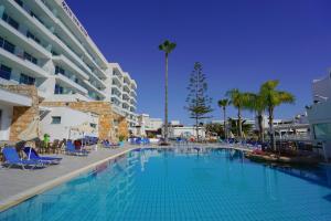 a large swimming pool next to a large building at Melini Hotel Suites in Protaras