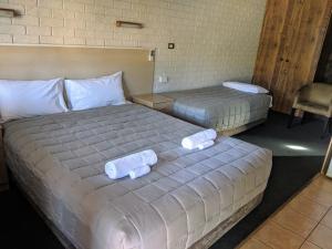トゥイード・ヘッズにあるシティ ライツ モーテルのホテルの部屋にはタオルが敷かれたベッドが2つある