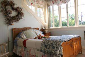a bedroom with a bed with areath on the wall and windows at Eureka Street Inn in Sutter Creek +15 photos