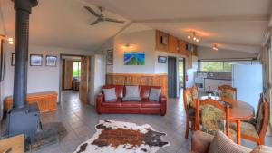 a living room with a red couch and a table at Discover Bruny Island Holiday Accommodation in Alonnah