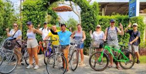 een groep mensen op fietsen die poseren voor een foto bij Riverside Park Eco Resort in Vĩnh Long