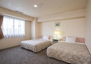 Postel nebo postele na pokoji v ubytování Komoro Grand Castle Hotel