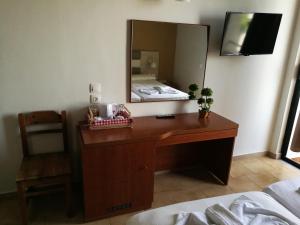 a bedroom with a desk with a mirror and a bed at Golden days in Afantou
