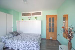 sypialnia z łóżkiem i drewnianymi drzwiami w obiekcie Calella Studio w mieście Calella