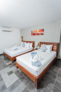 duas camas num quarto com duas mesas em Home Chic Hotel em Phnom Penh