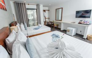 um quarto de hotel com duas camas e uma secretária em Home Chic Hotel em Phnom Penh