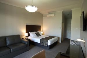 a hotel room with a bed and a couch at Southgate in Shepparton