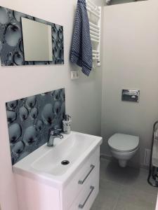 a bathroom with a white sink and a toilet at Romeo VIP apartamentai in Panevėžys