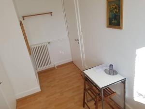 a white room with a table and a stool at Chambres meublées Prilly - Lausanne in Prilly