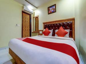 a bedroom with a large bed with red pillows at Sarthak Palace - Near New delhi Railwey station in New Delhi