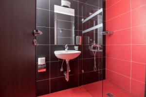 a bathroom with a sink and a red wall at Cosmopolit in Athens