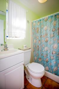 een badkamer met een toilet en een douchegordijn bij Leucadia Beach Inn in Encinitas