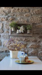 una mesa con un plato de comida en una pared de piedra en Casa da Chã!, en Antigo de Arcos