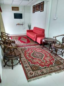 sala de estar con sofá rojo y alfombra en Bonda Guesthouse I, en Paka