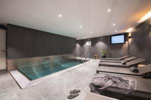 a bathroom with a swimming pool and a tv at Au Clos du Lac in Gueux