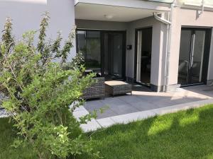 eine Veranda eines Hauses mit einer Bank und Gras in der Unterkunft Luxus Apartment Lake&City in Friedrichshafen