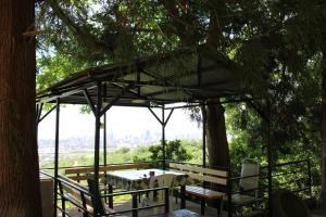 a patio with a table and chairs under a tree at Holiday Home Data in Batumi