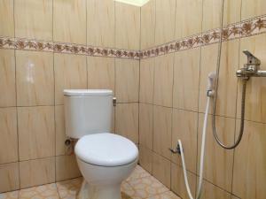 un bagno con wc e doccia di De Hanami Homestay a Cirebon Altre 41 foto