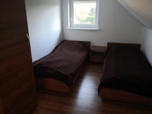 two beds in a small room with a window at Apartament bocian in Kruklanki